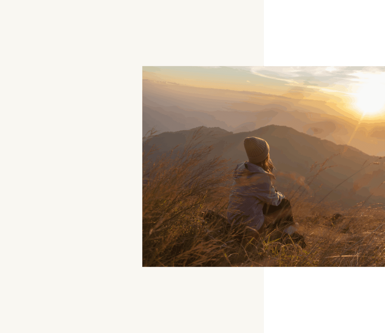 Person sitting on hill at sunset.